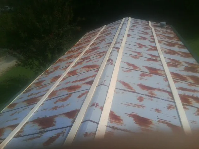Rusted metal roof panels with new wood purlins before replacement — Storm Damage Roof Repair in Kenesaw by Roofing Brothers