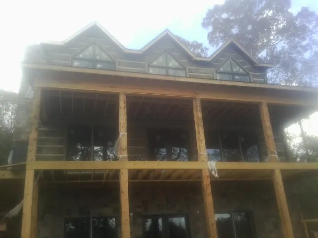 Dormers and porch framing on a large log home under construction — Roof Coating work by our crew in Kenesaw
