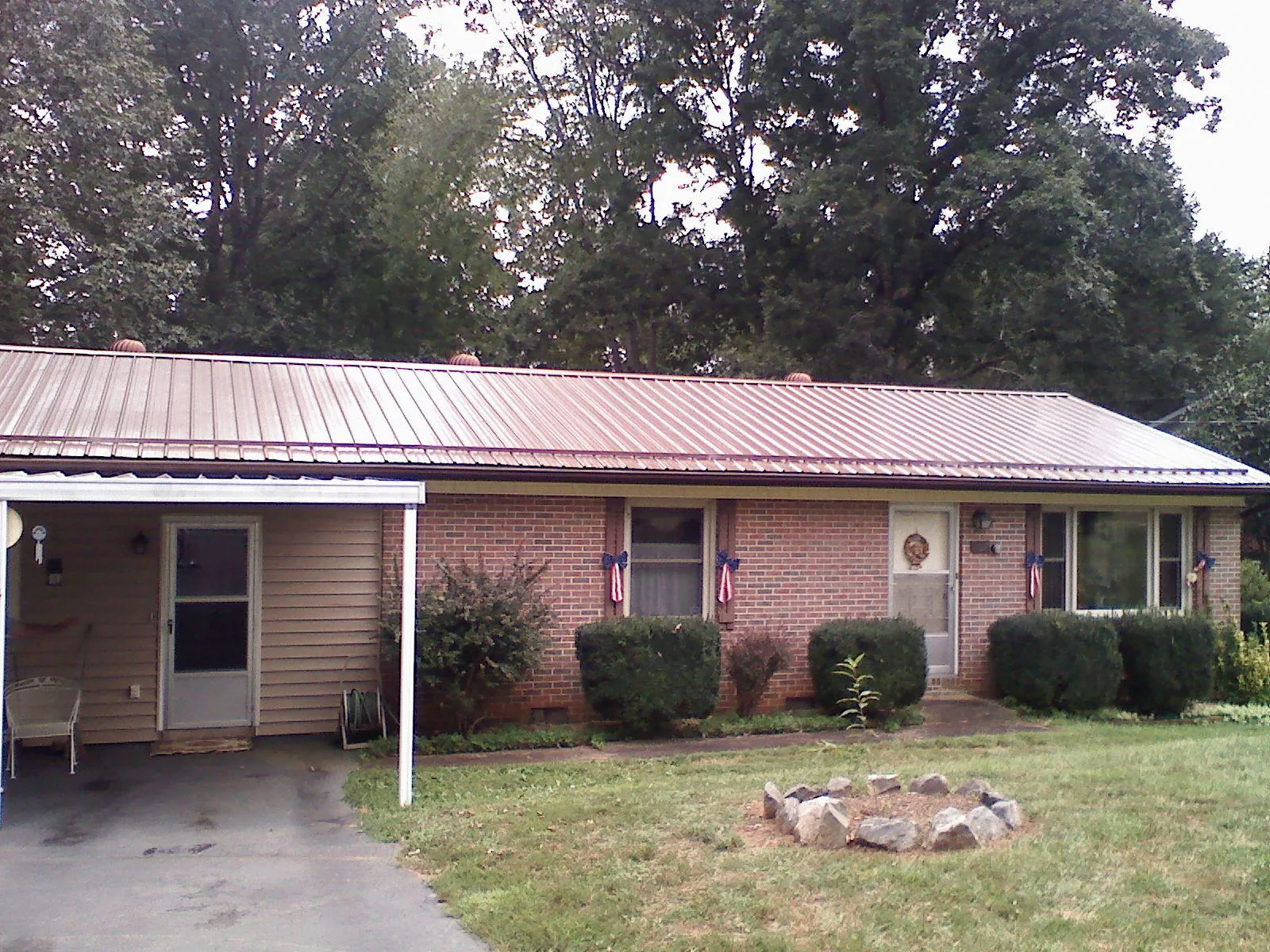 Bronze metal roof and carport on a brick ranch home — Roof Repair work by our crew in Kenesaw